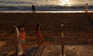 Una persona se ducha en la playa de la Barceloneta, en Barcelona, en mitad de enero.