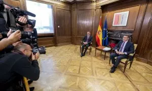 El presidente del Gobierno, Pedro Sánchez (i), y el líder del PP, Alberto Núñez Feijóo (d), posan para los medios de comunicación, durante una reunión, en el Congreso de los Diputados, a 22 de diciembre