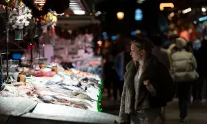 Una señora mira el género expuesto, en el Mercado de la Boquería, el pasado 14 de diciembre de 2023, en Barcelona.