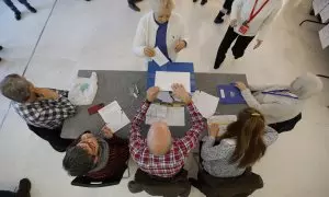 Una mujer ejerce su derecho al voto en un colegio electoral en Santiago de Compostela al comienzo de la jornada electoral en Galicia, este domingo.
