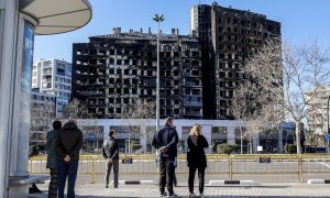 Varias personas observan el edificio incendiado del barrio de Campanar, a 24 de febrero de 2024, en Valencia