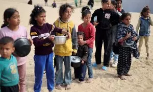 Niños palestinos esperan para recibir comida de una tienda de ayuda humanitaria, en Rafah, a 27 de febrero de 2024.