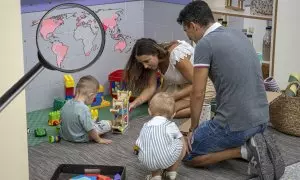 07/03/2024 Un padre y una madre juegan con sus hijos en un colegio.