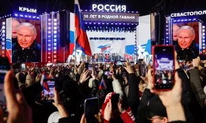 Unas pantallas gigantes muestran el rostro del presidente de Rusia, Vladimir Putin, en un acto en la Plaza Roja de Moscú, para conmemorar el décimo aniversario de la anexión rusa de Crimea de Ucrania, un día después de ser declarado de las recientes elecc