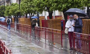 20/3/24 - Foto de archivo de una pareja con paraguas en Sevilla durante la Semana Santa de 2022.
