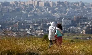 Dos personas se abrazan y observan Gaza cerca de la frontera entre Israel y el enclave, el 23 de marzo de 2024.