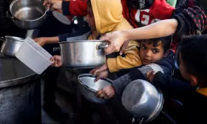 Un grupo de niños palestinos espera para recibir comida y ayuda humanitaria.