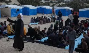 Ciudadanos gazatíes rompen el ayuno y comen todos juntos en medio del Ramadán en el campo de refugiados de Rafah este 27 de marzo de 2024.