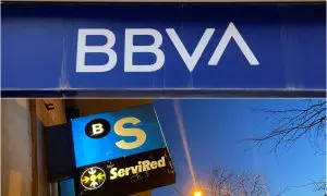 Los logos del BBVA y del Banco Sabadell en sendas oficinas bancarias.