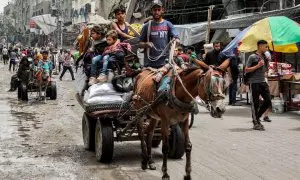 Un hombre conduce un carro tirado por caballos con niños y pertenencias mientras evacuan el campo de Yabalia para refugiados palestinos en el norte de la Franja de Gaza el 11 de mayo de 2024.