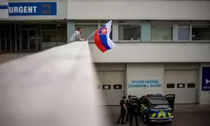 Un hombre ondea la bandera nacional eslovaca frente al hospital donde el primer ministro eslovaco, Robert Fico, está siendo tratado después de recibir varios disparos el pasado 15 de mayo.