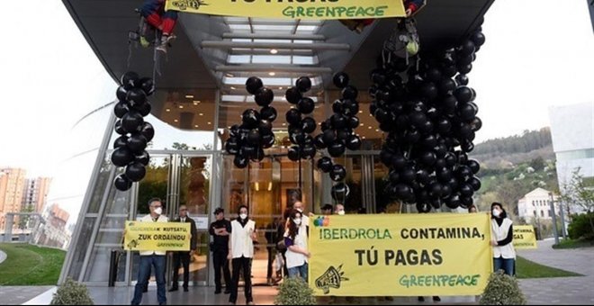 Activistas de Greenpeace despliegan pancartas en la sede de las eléctricas