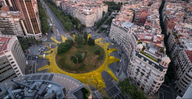 Greenpeace pinta un sol gigante en la plaza Francesc Macià de Barcelona por las renovables