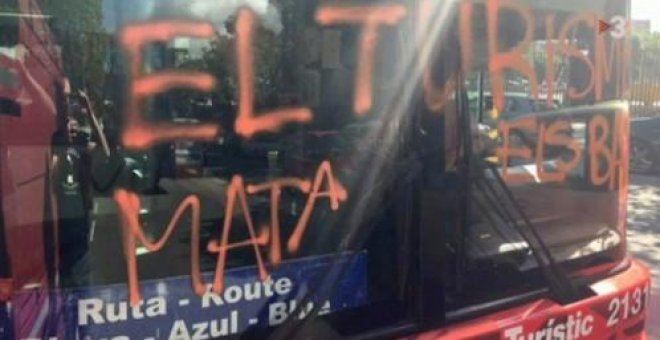Cuatro encapuchados paran un bus turístico y hacen una pintada contra el turismo en Barcelona