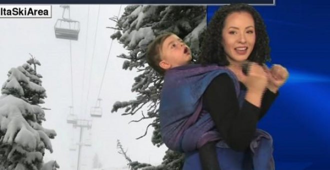Una presentadora da el tiempo con su hijo cargado a cuestas