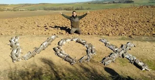 Un joven cazador forma la palabra Vox con decenas de liebres muertas