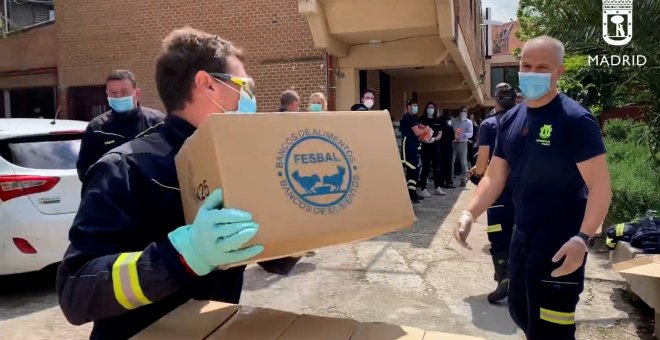 Bomberos ayudan en la entrega de alimentos en el barrio de Vallecas