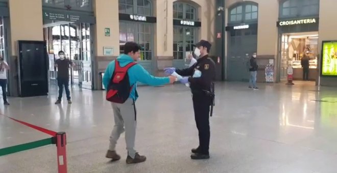 Policía y GC reparten mascarillas en transporte público de Valencia