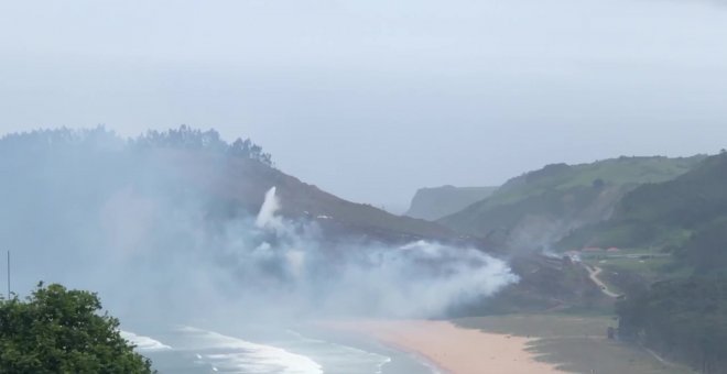 Helicóptero de Bomberos sofoca un incendio en la playa de Rodiles en Asturias
