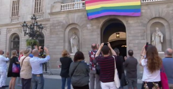 La bandera LGTBI ondea a modo de pancarta en la fachada del Ayuntamiento de Barcelona