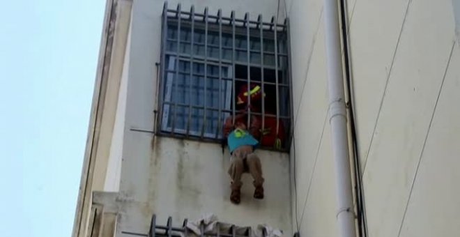 Angustioso rescate de los bomberos a un niño colgado en un quinto piso en China