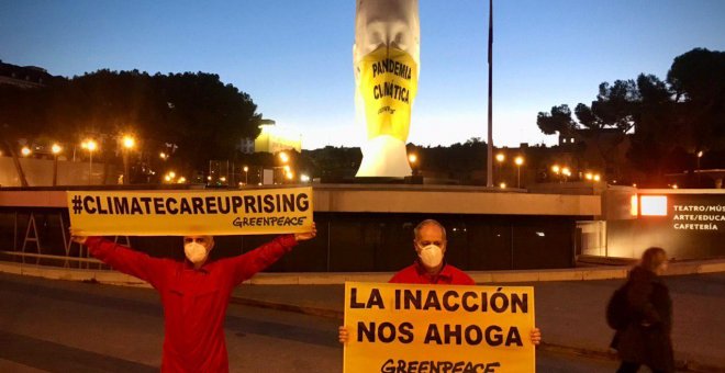 Greenpeace pone una mascarilla gigante a la estatua de la plaza de Colón en Madrid para denunciar la pandemia climática