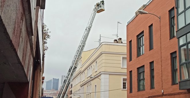 Bomberos trabajan en el incendio en una cubierta de un edificio de Tetuán