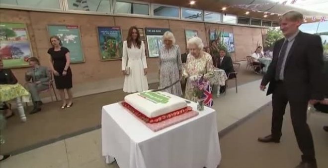 La reina Isabell II corta una gran tarta con una espada en un evento solidario en Reino Unido