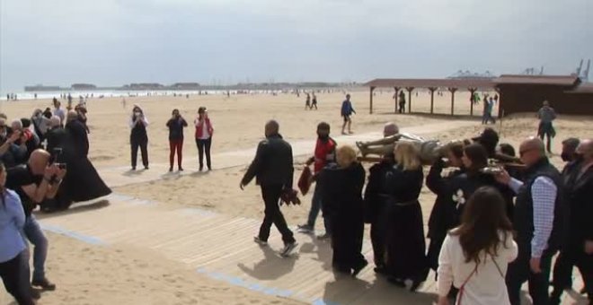 El Cristo del Salvador acude a la playa de la Malvarrosa en procesión con bañistas de por medio