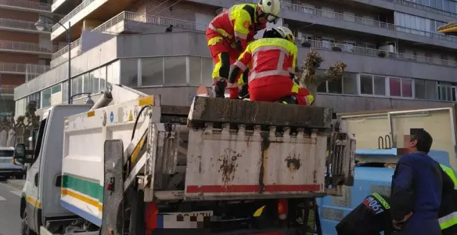 Los bomberos liberan a un operario cuya mano quedó atrapada en la cuba de un camión