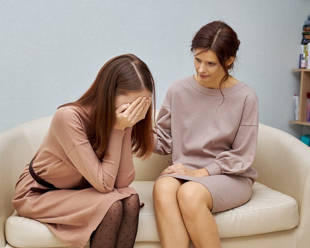 Mujeres sentadas en sofá en consulta del psicólogo