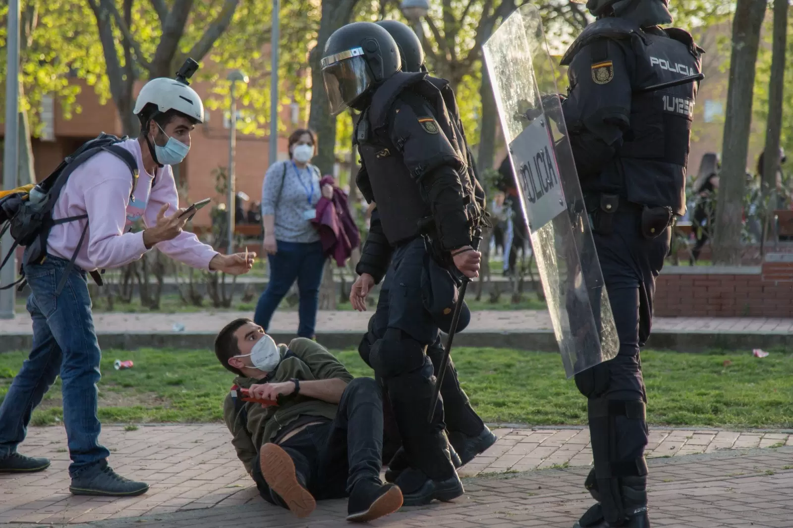 El periodista Guillermo Martínez, en el suelo junto a dos policías antidisturbios, el 7 de abril de 2021, día del mitin de Vox en Vallecas. — Fernando Capdepón Arroyo