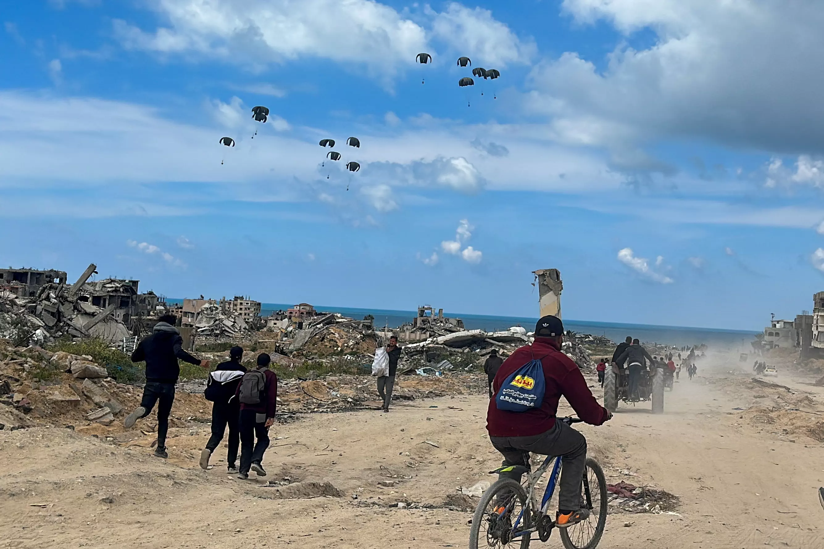 Un grupo de palestinos va hacia la playa para recoger la ayuda lanzada desde un avión, en medio del actual conflicto entre Israel y Hamás, en el norte de la Franja de Gaza, a 25 de marzo de 2024. — Stringer / REUTERS