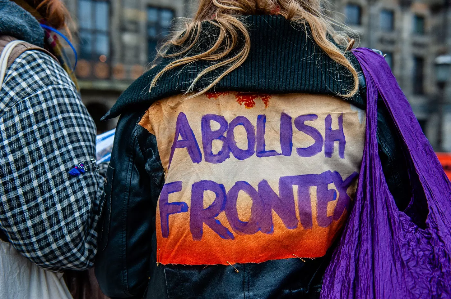 Una mujer lleva un parche en la espalda contra Frontex, durante una manifestación en apoyo de los refugiados en Libia, en Ámsterdam, el 18 de diciembre de 2021. — ROMY ARROYO FERNÁNDEZ / AFP