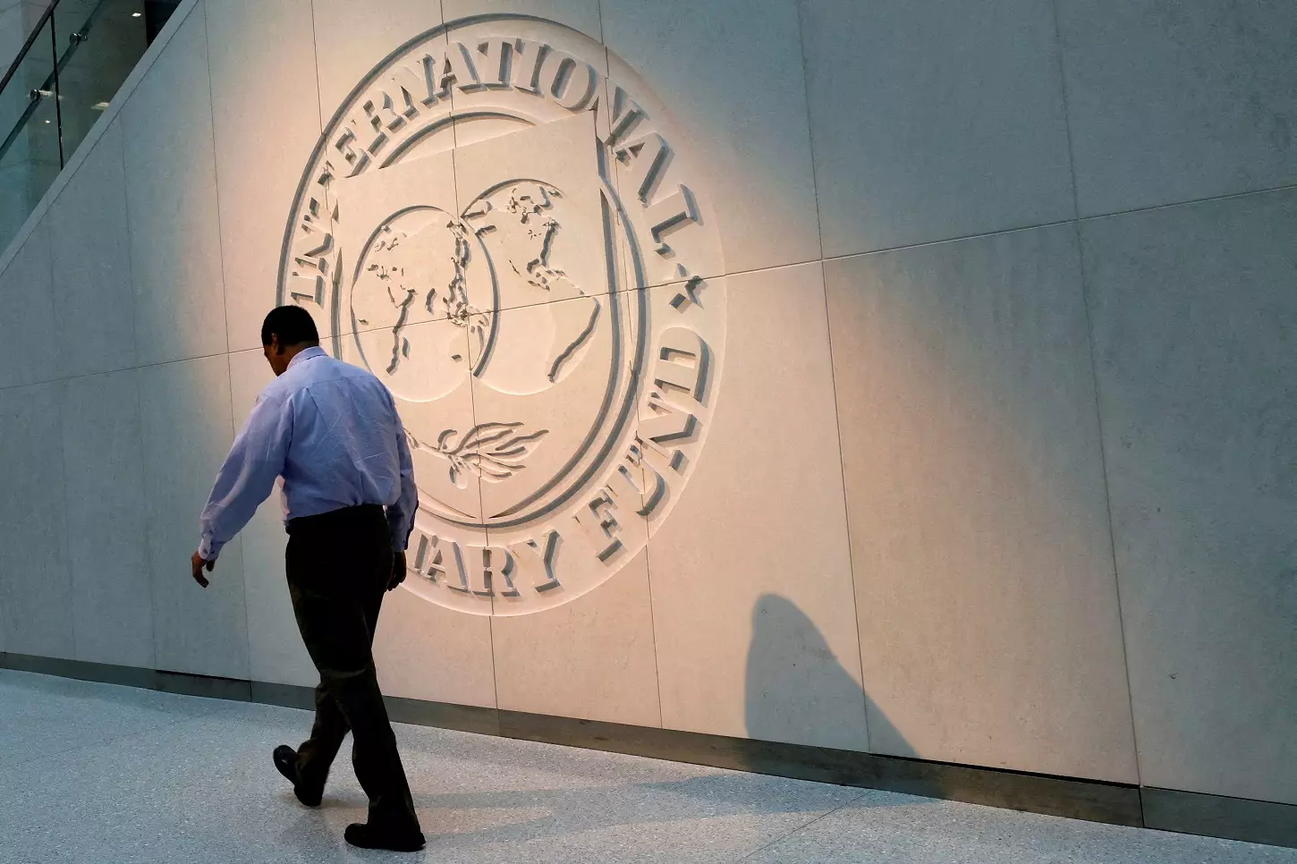 Un hombre pasa caminando por delante del logo del Fondo Monetario Internacional (FMI), en su sede en Washington. — REUTERS/Yuri Gripas