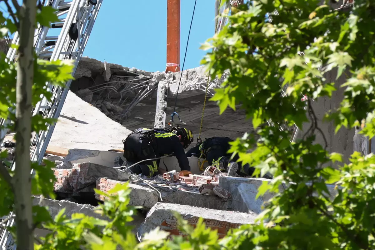 Dos bomberos trabajan entre los escombros del edificio derrumbado este martes en Madrid.— Fernando Villar / Europa Press