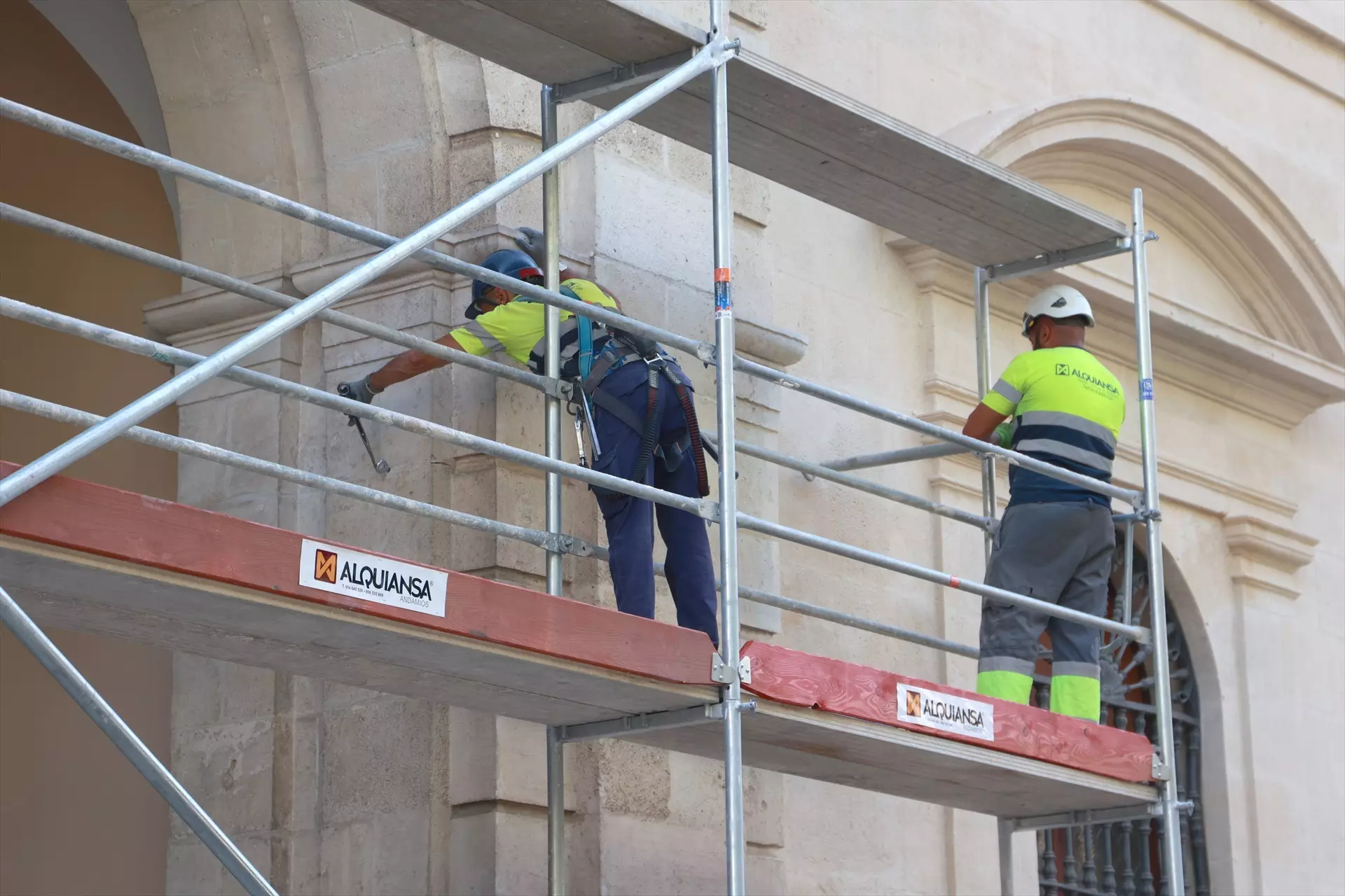 Dos operarios trabajan en el montaje de unos andamios en Sevilla. — Europa Press