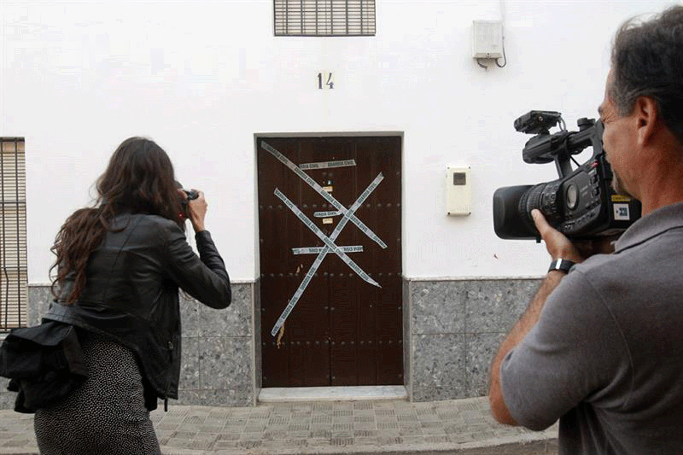 Miembros de los medios de comunicación sacan imágenes del domicilio del supuesto autor del asesinato.- EFE