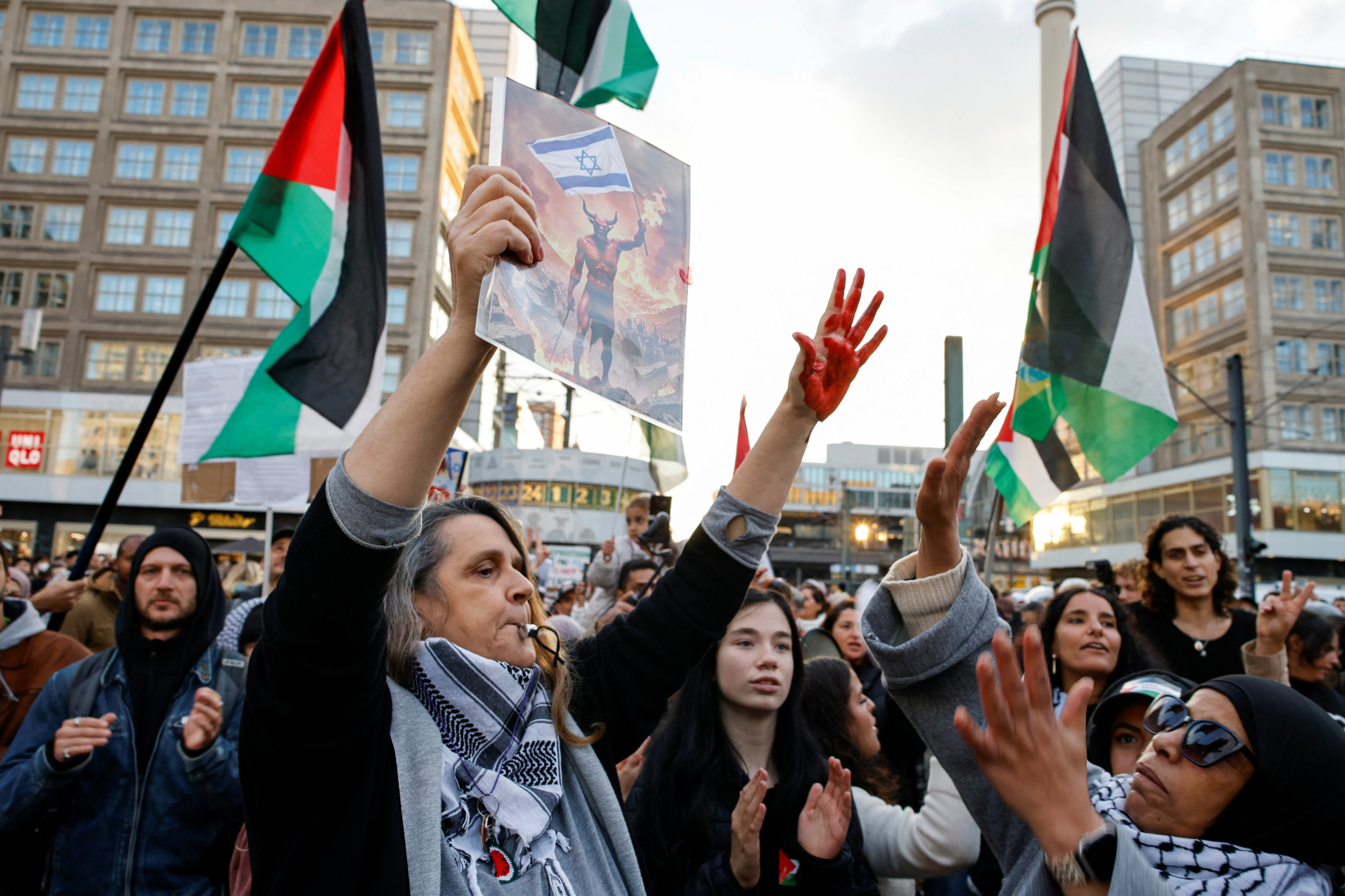 Una persona muestra las manos manchadas de rojo en la manifestacion de Berlin.