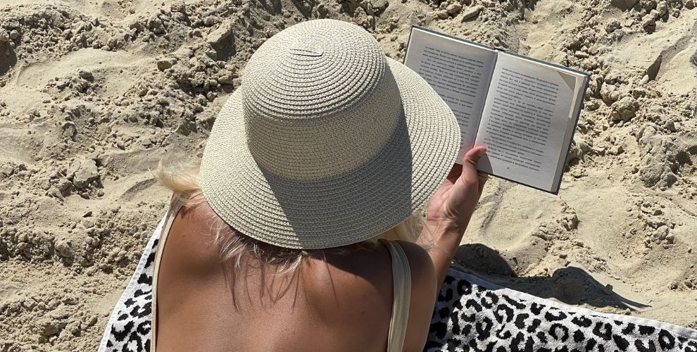 Chica leyendo un libro en la playa. (Fuente: Unsplash)