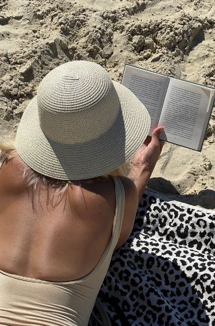 Chica leyendo un libro en la playa.(Fuente: Unsplash)