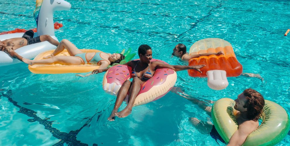 Grupo de personas en una piscina con hinchables fantasía. (Pexels)