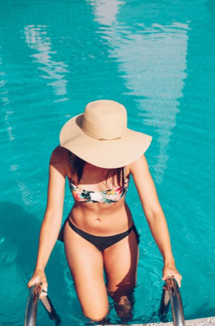 Chica en bikini posando en una piscina